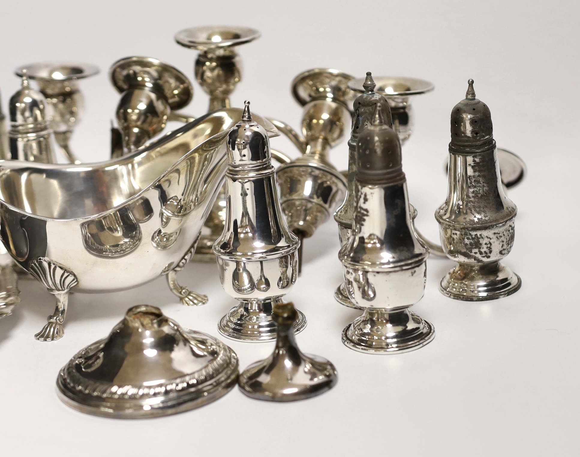 A quantity of assorted sterling or 800 standard white metal items including eight pepperettes, damaged pair of dwarf candelabra, sauceboat on stand etc.